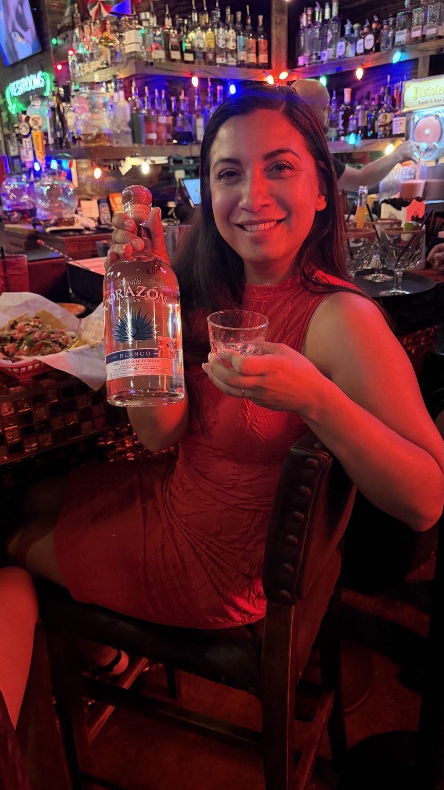 Guest holding a featured Corazón Tequila bottle and sample during an on-premise activation